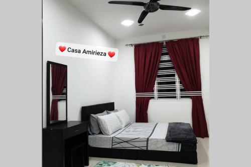 a bedroom with a bed and a ceiling fan at Casa Amirieza in Port Dickson
