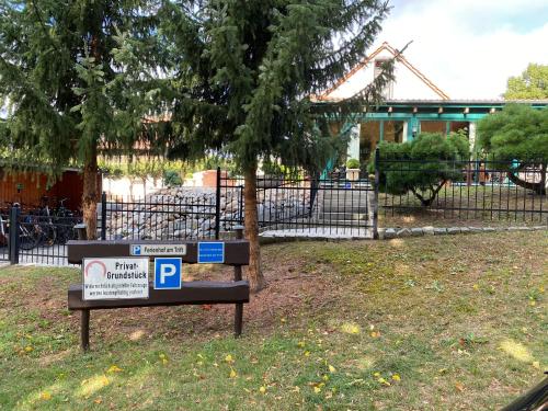 a parking sign in front of a fence with a tree at Ferienhof am Trift in Bad Saarow