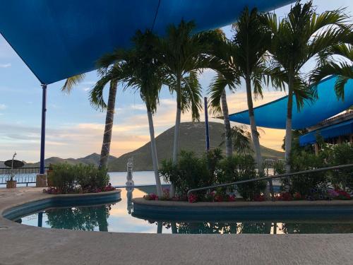 a resort with palm trees and a swimming pool at Casa de la Aduana Hotel Boutique in Topolobampo