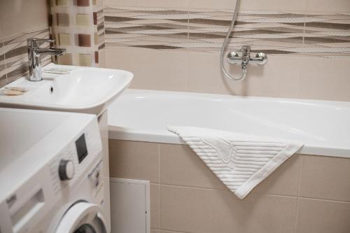 a bathroom with a sink and a washing machine at Центр міста! Затишні квартири в новобудові! in Uzhhorod