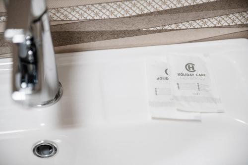 a bathroom sink with a bathroom card on the counter at Центр міста! Затишні квартири в новобудові! in Uzhhorod