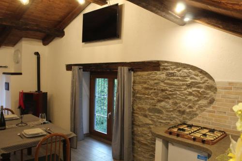 a kitchen with a stone wall with a television on the wall at iCAVA in Rubiana