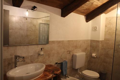 a bathroom with a sink and a toilet and a mirror at iCAVA in Rubiana