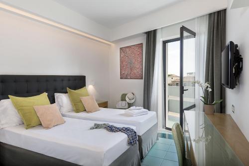 two beds in a small room with a window at Rada Siri in Montepaone