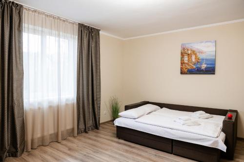 a bedroom with a bed and a large window at Центр міста! Затишні квартири в новобудові! in Uzhhorod