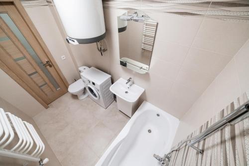 a bathroom with a tub and a toilet and a sink at Центр міста! Затишні квартири в новобудові! in Uzhhorod