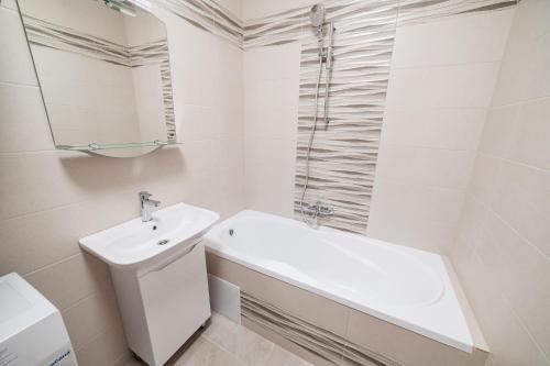 a white bathroom with a sink and a bath tub at Центр міста! Затишні квартири в новобудові! in Uzhhorod