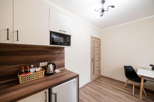 a kitchen with white cabinets and a wooden counter top at Центр міста! Затишні квартири в новобудові! in Uzhhorod