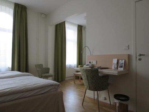 a hotel room with a bed and a desk and a table at Best Western Hotel Royal in Malmö
