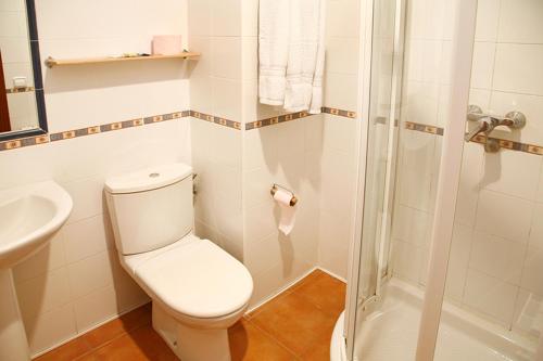 a white bathroom with a toilet and a shower at Alojamiento Numancia Pensión in Burgos