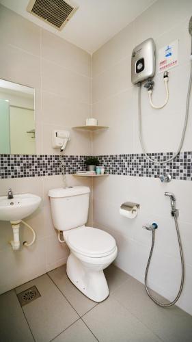 a bathroom with a toilet and a sink and a shower at J.G. Resort in Pengerang