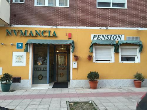 un bâtiment jaune avec l'entrée d'un restaurant dans l'établissement Alojamiento Numancia Pensión, à Burgos