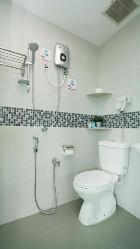 a bathroom with a toilet and a shower at J.G. Resort in Pengerang