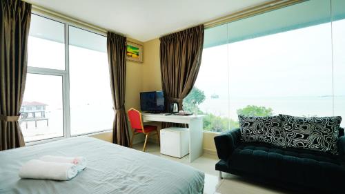 a bedroom with a bed and a couch and a desk at J.G. Resort in Pengerang