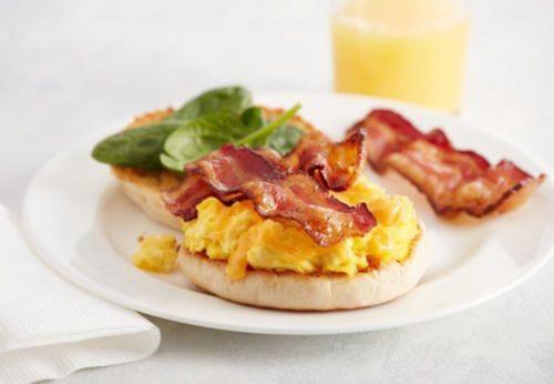 a plate with two breakfast sandwiches with bacon and greens at Crowne Plaza Chicago SW - Burr Ridge by IHG in Burr Ridge