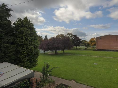 a view of a park with trees and a building at The Sycamore Guest House in York