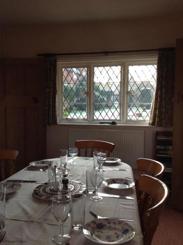a table with a white table cloth on it with glasses at Pekes Tudor View in Hailsham