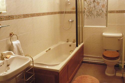 ein Badezimmer mit einer Badewanne, einem WC und einem Waschbecken in der Unterkunft Pekes Tudor View in Hailsham
