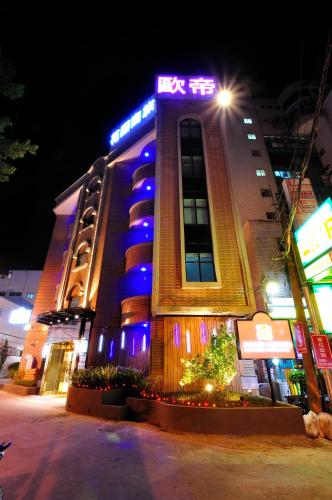 a large building with blue lights on it at night at Audi Garden Business Hotel in Taoyuan