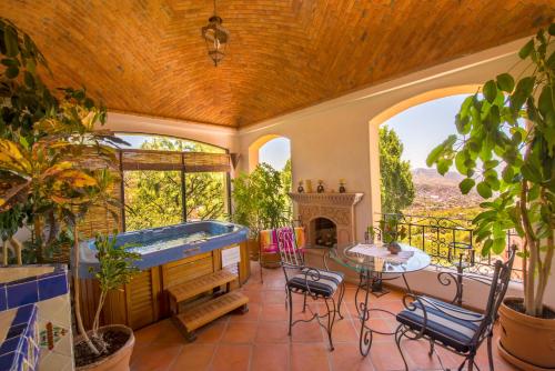 a large room with a hot tub and a table and chairs at Casa Estrella de la Valenciana Hotel Boutique in Guanajuato