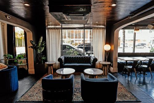 a restaurant with chairs and tables and a couch at H by H Hospitality in Los Angeles