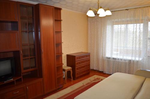 a bedroom with a bed and a dresser and a television at Квартира на Дарвина in Tver