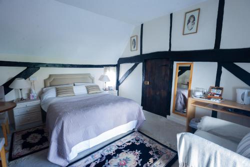 een slaapkamer met een bed, een bureau en een stoel bij The Potters Arms in Amersham