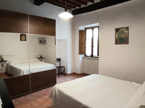 a bedroom with two beds and a window at Appartamento Porta Nova in Rapolano Terme