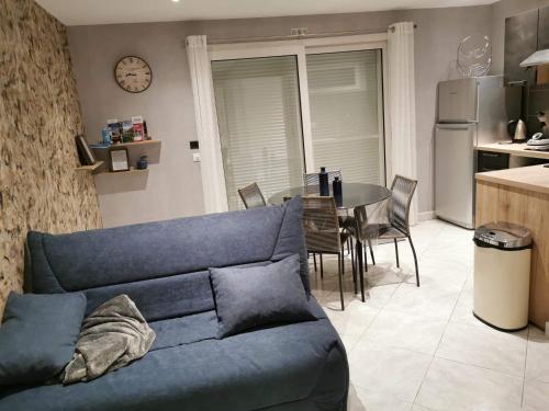 un salon avec un canapé bleu et une table dans l'établissement A l instant présent, à Brison-Saint-Innocent