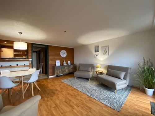 ein Wohnzimmer mit 2 Stühlen und einem Tisch in der Unterkunft Terrassenpark Apartments in Sasbachwalden