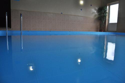 a large blue swimming pool in a room at SN Hotel in Sloboda Zasluchʼ