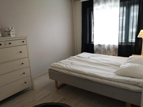 a bedroom with a bed and a dresser and a window at Apartment Vuorikatu 35 in Kuopio