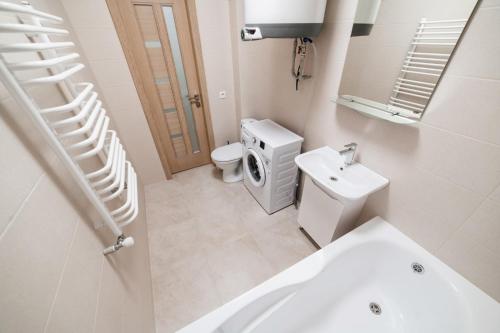 a white bathroom with a toilet and a sink at Центр міста! Затишні квартири в новобудові! in Uzhhorod