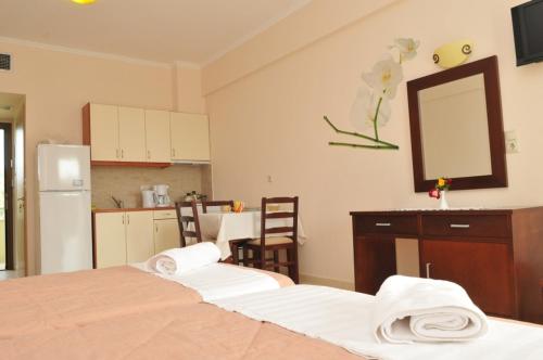 a room with two beds and a kitchen with a mirror at Finiki Plaza in Methoni