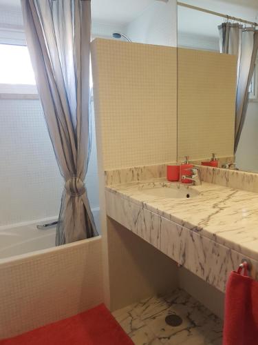 ein Badezimmer mit einem Waschbecken, einem Spiegel und einer Badewanne in der Unterkunft Lagos Marina Side Apartment in Lagos