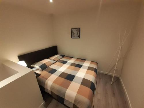 Un dormitorio con una cama con una manta a cuadros. en Appartement DELUXE, en Tilburg