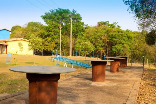 a row of picnic tables in a park at Chalés Cantinho da Roça in Capitólio