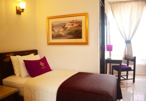 ein Schlafzimmer mit einem Bett und einem Wandgemälde in der Unterkunft Hotel Aztlan in Jalisco