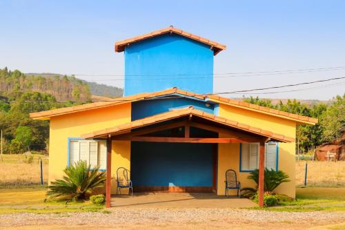 a small house with a blue tower on top at Chalés Cantinho da Roça in Capitólio