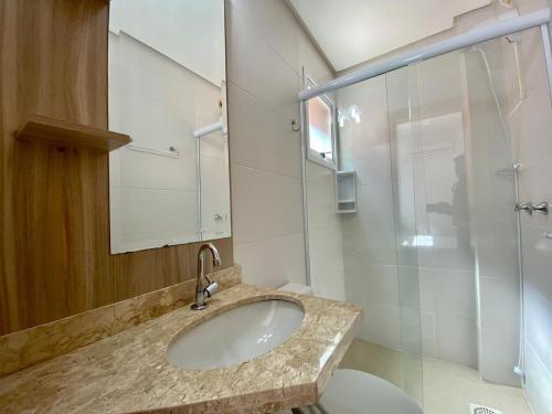 ein Bad mit einem Waschbecken und einer Dusche in der Unterkunft Apto 2 dom e 3 quadras do mar edifício Silviane Gomes 7 andar in Capão da Canoa