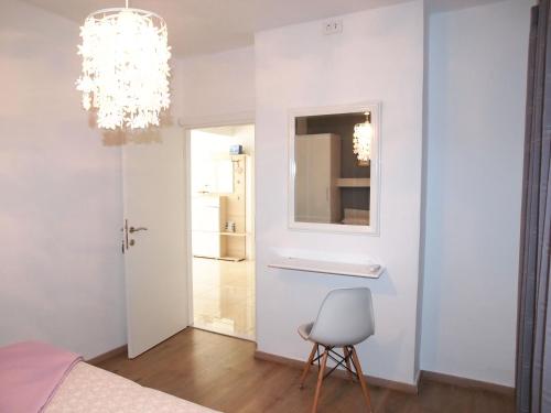 a bedroom with a chandelier and a chair in it at Apartmani Igor in Makarska