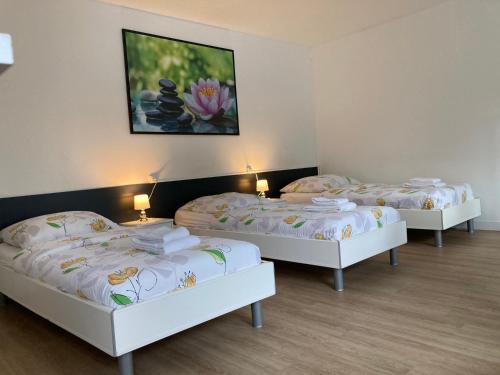 a group of three beds in a room at Studios Lora RM 860 in Saint-Louis