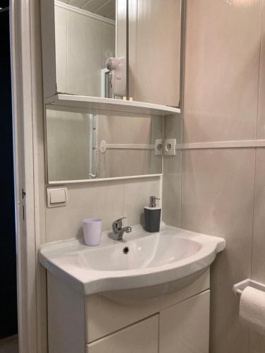 a bathroom with a white sink and a mirror at Studios Lora RM 860 in Saint-Louis