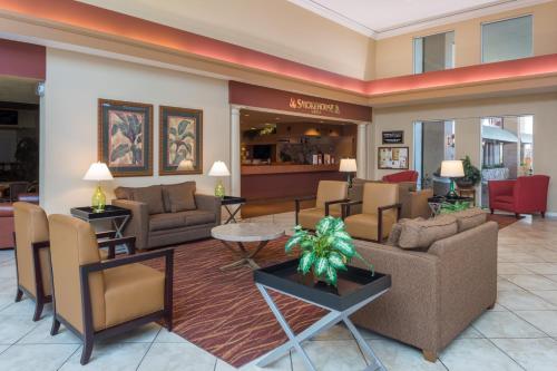 
a living room filled with furniture and a large window at Ramada by Wyndham Kissimmee Gateway in Orlando
