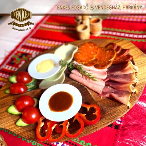 a plate of food with meat and vegetables and sauce at Tenkes Fogadó és Vendégház Harkány in Harkány