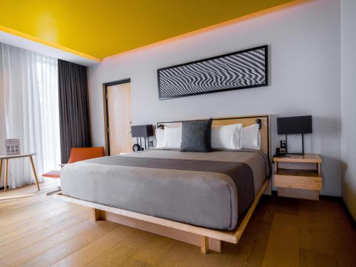 a bedroom with a large bed and a yellow ceiling at Galeria Plaza San Jeronimo in Mexico City