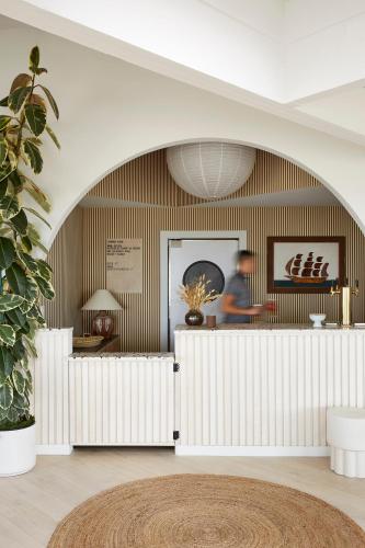a lobby with a white counter and a person in the background at White Water in Cambria