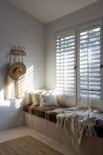 a window seat in a room with white shutters at White Water in Cambria