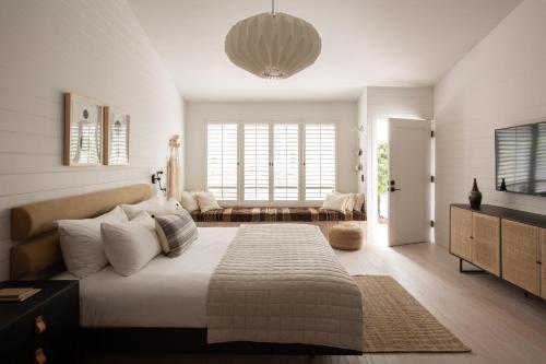 
a bedroom with a white bed and white walls at White Water in Cambria
