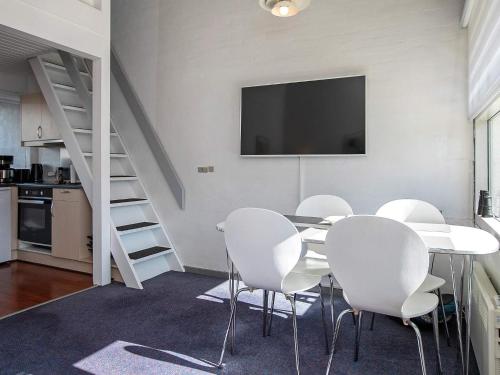 a dining room with a table and white chairs at 5 person holiday home in V ggerl se in Bøtø By